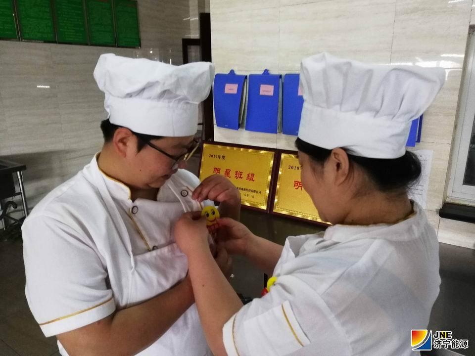 安居煤矿职工食堂职工佩戴“笑脸牌”上岗.jpg